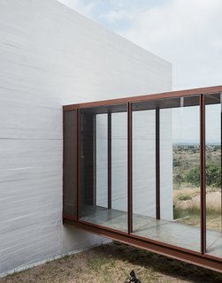 Glass-and-steel corridors link each of Austin and Lida's studios to the main pavilion, where they share the kitchen and a central living and dining space.