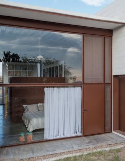 Welded-sheet partitions carve out a sleeping area and mirror the exterior palette, blurring boundaries between inside and outside. Inspired by the hue of artist Richard Serra's Cor-Ten sculptures, the Lowreys had all of the steel primes and painted with a hand-mixed blend of matted paint from Sherwin-Williams.