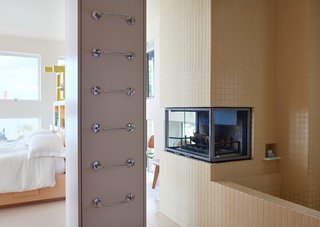 Thank Sottsass for the Most Memphis House Imaginable - Photo 9 of 14 - Idiosyncratic touches, including a recessed fireplace and a tall, ladder-like series of towel rungs, also mark the adjacent bathroom, outfitted with a fireplace near the tub.