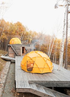 One North Face tent sits atop a deck; another caps the main building, which contains a kitchen and dining area.