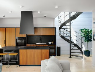 Emilie Bédard and Maria Rosa Di Ioia of EM Architecture gave Erik Rydingsvärd’s top-floor apartment in a Montreal triplex a subdued, modern look that evokes his native Denmark. The range hood and satin-finished teak cabinets are by Kastella. The floors are Douglas fir and the walls are spruce, painted white.