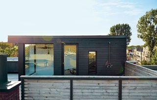 Rydingsvärd often cooks out on his terrace, which offers a view of Mount Royal. The volume housing the sauna is clad in cedar planks that were painted black. The door and windows are by Alumilex, and the custom outdoor shower is by Avantage Plus.