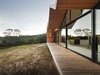 Modern home with House, Outdoor, Wood Siding Material, Large Patio, Porch, Deck, Wood Patio, Porch, Deck, and Slope. Constructing a largely timber house in a bush fire-prone landscape wasn’t easy. “We had to negotiate with the council and building surveyor,” Crump explains. To solve the challenge, the architect designed an outer, protective skin for the home that’s clad with metal; it pushes beyond the building envelope to provide covering for outdoor living spaces. The inset walls are lined with local shiplap Celery Top Pine. Photo 2 of Lookout House