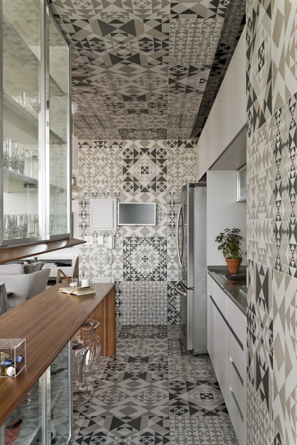 The graphic tile covers the floor, walls, and ceiling. The kitchen millwork was done by Inovart Carpentry.