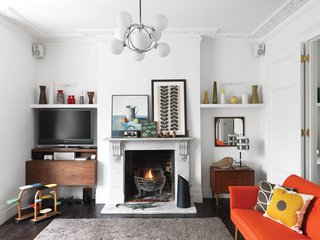 Light My Fire<br><br>"I didn’t want to compromise the Victorian nature of the house," she says. Although the original fireplace was in good shape, the flooring needed to be replaced. Kiely didn’t want to use new wood, so she sourced the weathered ebony-colored boards from an architectural salvage yard. "I wanted the floors to really feel like they were part of the house," she says. Kiely found the rug at Heal’s and the chandelier and art are vintage.