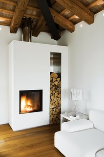 A firewood nice and hearth infuse the interior of a renovated farmhouse in Italy with coziness. Photo by Helenio Barbetta.