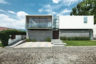 Architect Joaquin Castillo blends inexpensive materials, the odd splurge, and a refined modernist sensibility to create an affordable weekend house for brothers Alfredo and Guillermo Oropeza. The facade is a juxtaposition of rough-hewn local stone, smooth concrete, glass, and steel—the material palette used throughout the structure.