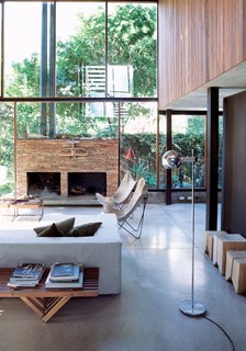 The living room resembles a Sticotti furniture showroom: The architect designed the couch, coffee tables, and stumplike stools. The fireplace is made of stacked stone from San Juan, a nearby province.