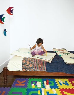 A traditional Indian twin bed in Mira’s room is outfitted in hand-stitched linens from Fabindia in Delhi. The toy blocks are from KID-O.