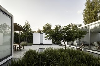 A Minimalist Mexican Retreat Uses an Array of Strategies to Beat the Heat - Photo 4 of 7 - One of the biggest challenges of the project was keeping the open courtyard cool enough for the residents to enjoy it. The architects used a low impact water feature to create ambient cooling and two native flamboyant trees to provide shade.
