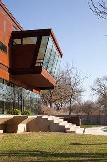 Here's a view of the steel and glass master bedroom as it cantilevers over the patio and yard. You can see the cantilevered concrete patio in the foreground. The structure of the building is more common to commercial construction—steel framing with metal studs, storefront glass, and a concrete topping slab poured onto corrugated metal decking at the second floor. Photo by Brian Mihealsick.