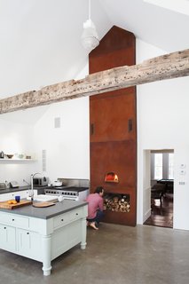 Givone considers his pizza-cooking technique in front of the custom built wood-fired oven.