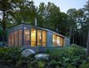 Sited on a lake near Bracebridge, Ontario, this small-footprint family cottage was designed by Toronto firm superkül to integrate with its natural surroundings and minimize its environmental impact. The clients, a married couple, had mixed feelings about going completely modern with their cabin's aesthetic, so the architects created a sculptural wood form to bridge the gap between traditional and contemporary. Photo by Shai Gil. Photo of Stealth Cabin modern home