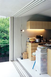 Custom-made paulownia cabinets and a roomy balcony keep the compact second-floor living-dining-kitchen area from feeling cramped or cluttered.