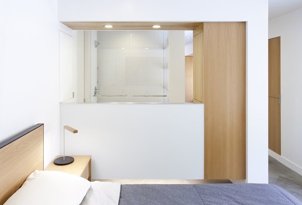 The option of having an extra bedroom for their growing family was an attractive one for Scholz and Preskill as they looked to expand the living area of their cozy home. In doing so, they found themselves “cramming a full program into not that much space,” says Scholz. To achieve this, and still maintain a sense of fluidity and openness, the new master bedroom and bathroom were designed as a nontraditional open-concept space, without a continuous dividing wall between them. The light, airy bedroom features a custom LW bed and wall-hung side tables, both by San Francisco-based OHIO Design, along with a steel-and-white-oak lamp by Rich Brilliant & Willing. Photo of KS Mission modern home