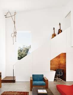 1920s Bungalow Plus Modern Addition Equals Perfect Austin Home - Photo 1 of 11 - Sam Shah and Anne Suttles asked architect Kevin Alter to renovate their 1920s bungalow in Austin, Texas, and add an addition, which contains a living area downstairs and an office upstairs. They tucked an office nook under the stairs; the Eames chair is a hand-me-down from Shah’s father.