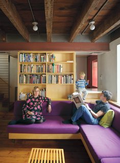 Family Home Renovation in Brooklyn - Photo 5 of 28 - The exposed ceiling beams and inserted steel framing system are visible in the lower level, where Lange and Dixon relax with their son Paul.