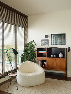 Modern Home Furnished With Flea Market Finds - Photo 11 of 17 - A Noé Duchaufour-Lawrance chair, Charlotte Perriand wall sconce, and Greta Grossman Grasshopper floor lamp round out a corner in the living room. Deau made the side table herself.