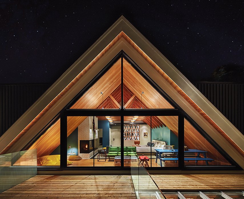 The Owner’s Suite at the Drake Devonshire is located under a dramatic A-frame clad with Douglas fir inside. John Tong and his team custom designed the bed and found the sofa, armchair, and red footstool at the Brimfield Antique Market. The windows are by Alumilex, and the interior paint is Benjamin Moore’s Buckland Blue and Colorado Gray.