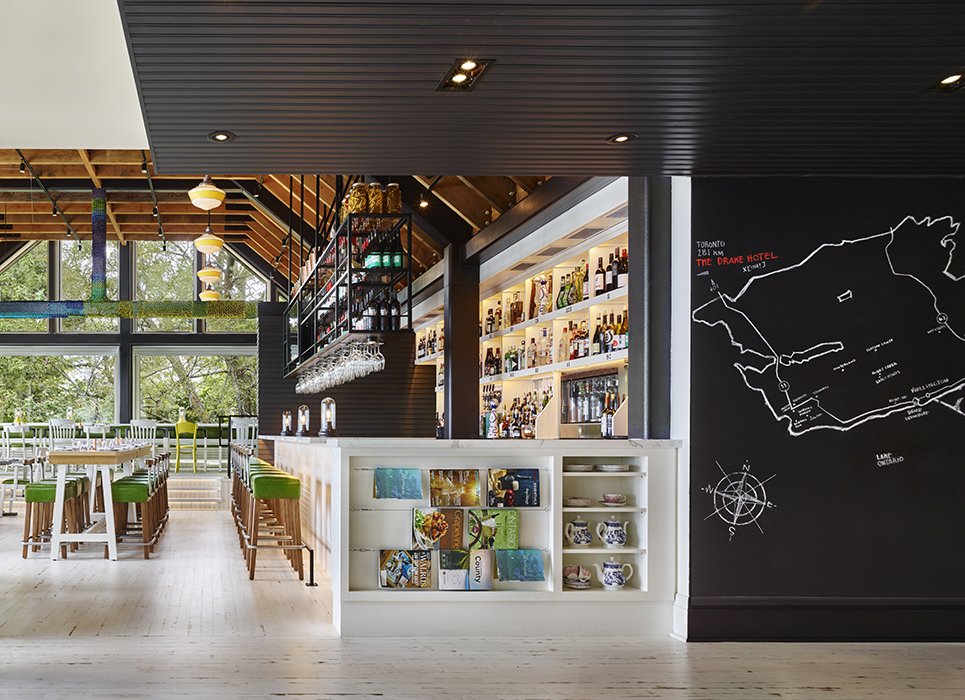The Drake Devonshire is located on the shores of Lake Ontario in the town of Wellington. In addition to the guestrooms and suites, the boutique hotel offers amentites including a restaurant and bar stocked with local wines. Designer John Tong left the Douglas fir beams exposed in the dining area exposed to create a