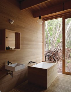 10 Ideas For Designing With a Modern Bathtub - Photo 6 of 10 - Houle designed the ofuro tub in the master bath to mesh with the home’s tallowwood wall paneling. The Ikea sink is outfitted with Vola faucets.