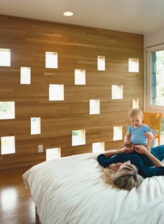 Minneapolis, MN - Photo 2 of 9 - Karie and Mason enjoy a playful loll on the bed in the Deans’ new master bedroom. The perforated wall facing the neighbors’ backyard offers a great deal of diffuse light while still managing to conceal the Deans’ boudoir from prying eyes.