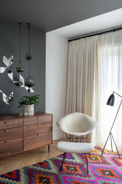 In a corner of the master bedrooms, a black Greta Grossman Grasshopper lamp sits next to a Bertoia Diamond chair with matching ottoman. Lead designer Chelsie Lee says the Turkish kilim was "a lucky vintage find." A custom Jessica Helgerson cut mirror design is set off by hanging terrariums, made in Vancouver Score + Solder. The American Modern dresser in walnut is from Design Within Reach. Photo 6 of Color Splash modern home