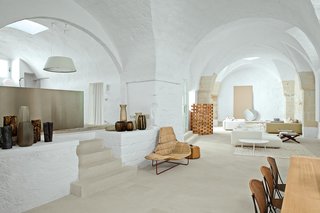 A geometric patterned rug by Karpeta anchors pieces the couple designed for Zanotta, including three Pianoalto sofas and a scattering of indoor-outdoor Ninfea and Loto coffee tables. Also pictured is a Paraggi camp bed and wooden Zen screen for Exteta and a Morphing round mirror for Kos.