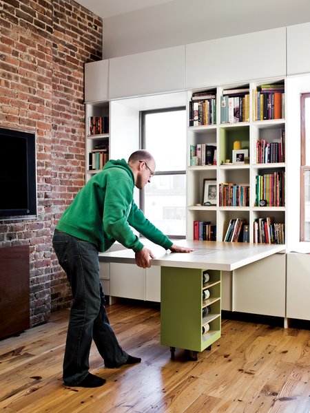 The table’s base, which itself is an additional storage container, rolls easily into place to support the surface.