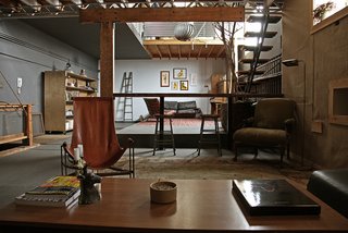 Number Five: A Co-Working Space in Venice Beach - Photo 2 of 14 - The bartop downstairs was salvaged from a church that was being torn down in the Southbay. Mathew Gerson, Brett Woitunsky and Paul Anderson built the bartop, and the steel legs are by Matthew Deters of Deterfabrik, a furniture fabricator who works in the space below Number Five. The post and beam holding it up are from the teardown across the alley. The steel/leather swoop chair and drop light are also built by Deters. Photo by Yardwork Co.
