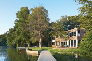 The New Zealand Native Who Can't Get Enough of the Garden State - Photo 5 of 9 - "The house’s narrow footprint works for us in terms of maximum exposure to the lake," says Gibbs (shown here with son Blake and dog Max on the shore of Lake Iosco). Glass walls and doors by Andersen also mean that Gibbs can keep a close eye on Blake when he’s playing in the yard. A plinth of reused bedrock found on the property has become an unintended place for active play.