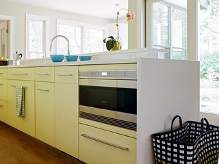 25 Bold Ways to Decorate with Yellow - Photo 7 of 25 - In northern New Jersey, a cramped kitchen is reborn as a welcoming space for cooking and entertaining. Decked out in a subtle yellow, the kitchen houses a Wolf drawer microwave tucked unobtrusively under the counter in the display island.