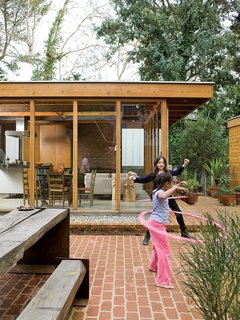 The courtyard acts like an outdoor living room, where the Arnolds’ daughter, Josie, plays freely, safe from nearby traffic. The family dines here most of the year at the custom-designed wood-and-steel table. The picnic table set reappropriates the century-old eucalyptus tree that once grew on the site.