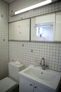 Tips for Tiny Bathrooms - Photo 4 of 12 - Linden used standard 2x2 daltile in the bathroom, but swapped out individual tiles to create a custom pattern. The toilet is by Duravit, the sink and cabinet are by Ikea, and the faucet is Kohler.