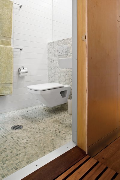 A skylight in the compact bathroom opens the space, and green tiles give the room a spa-like feel.
