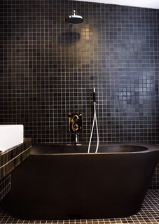 10 Ideas For Designing With a Modern Bathtub - Photo 1 of 10 - Black tiles and fittings lend the bathroom a dramatic look. The black bathtub is made of recycled plastic.