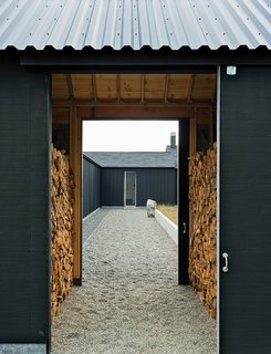 The gravel path leading to the front door passes through firewood storage and the central courtyard.