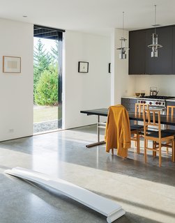 Lanterns from Stelton hang above the dining table and chairs Brothers designed. Nevamar laminate covers the kitchen cabinets, which feature pulls from Häfele. The range is by Wolf.
