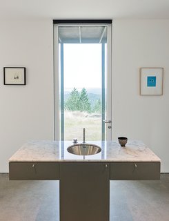 Seattle’s Special Projects Division designed the custom cabinetry throughout the house. A Vola faucet is integrated with the Carrara marble vanity.