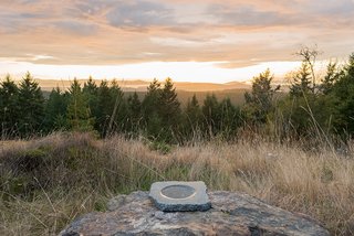 A stone bowl Brothers made in the 1990s is positioned on a rock.