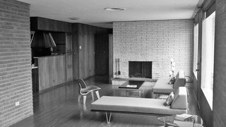 The Midcentury Spirit is Alive and Well in This Hudson Valley Escape - Photo 6 of 11 - Jordan put the living room on a diet, so to speak, reducing surfaces to open the space. He removed three feet of the existing stone fireplace surround and peeled back the ceiling to reveal steel structural beams, painted a red color matched to their original hue. The house’s footprint stayed the same. "Keeping most of the existing house was the biggest ‘green’ thing we did," says Jordan. Instead of recalibrating the plan, he focused on introducing daylight, adding insulation, and replacing windows to maximize views.