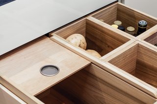 The residents store perishable items that don’t need refrigeration—like fruits, vegetables, onions, and garlic—in maple-lined pantry drawers.
