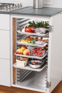 The residents incorporated speed racks into the cabinets. Typically found in restaurants, the racks offer chefs intermediate storage. In this case, the couple places food behind the cabinet until it’s ready to serve. After the meal is over, they can stow dirty dishes out of sight instead of interrupting the party with cleanup. To ensure trays slide in and out without catching the cabinet, King used hinges that allow the door to rotate 270 degrees.
