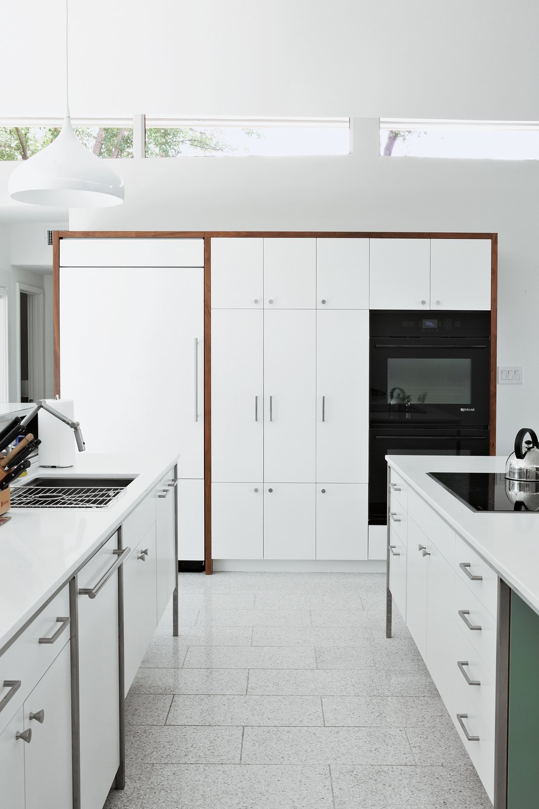 The cooktop, refrigerator, and wall ovens are by Jenn-Air; the sink and faucet are by Kohler; and the countertops are from Caesarstone.