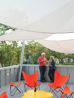 Mermet sun sails inspired by the nearby harbor shield Church and Jett from harsh sunlight, while practical, man-made planks by Veranda simulate wood but offer low maintenance and longevity. Bright orange Butterfly chairs from Circa50 add a pop of color.