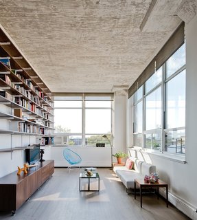 Brooklyn Loft Renovation Masters Storage With a Custom Cabinet Wall - Photo 9 of 10 - The windows on the right look out to Manhattan. The blue Acapulco chair echoes the aquatic tones of the bathroom tiles.