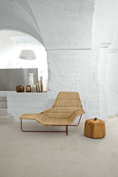 Modern Meets Ancient in a Renovated Italian Vacation Home - Photo 2 of 8 - Serafini and Palomba’s vacation home is a cavernous showcase for their own designs. In the living room, they created a one-off version of their Lama chaise longue, originally designed for Zanotta. The Zen Apple side table, also theirs, is from the Sen Line Collection by Exteta. The vases are by Guaxs.