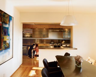 Hachigian and daughter Sosi in the renovated kitchen, which opens up to an outdoor dining terrace. The dining table was reconditioned from a language lab, its top wrapped in stainless steel. Dining chairs are by Kartell.