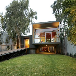 The entrance is reached via a long ramp perforated by uplights.