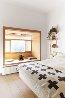 These Shop Owners Have a Killer Apartment Right Upstairs - Photo 10 of 10 - A Libri wall shelf by Michaël Bihain for Swedese sits next to a Koster bed by Carpe Diem in the master bedroom, where translucent shoji-style screens by Studio Junction offer privacy. The cast-iron kettle and electric brazier are used in the traditional Japanese tea ceremony.